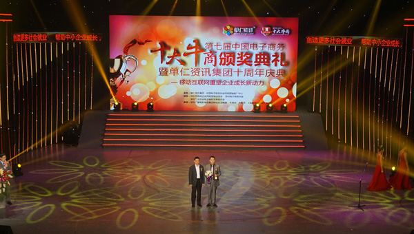 頒獎嘉賓爲(wei)本(ben)屆的(de)十大(da)牛商(shang)，富(fu)軒們(men)窗董事長(zhang)李昌安(an)頒髮(fa)獎杯與鮮花(huā)